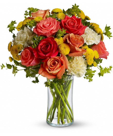 Bouquet of bright flowers and greenery in a clear glass vase