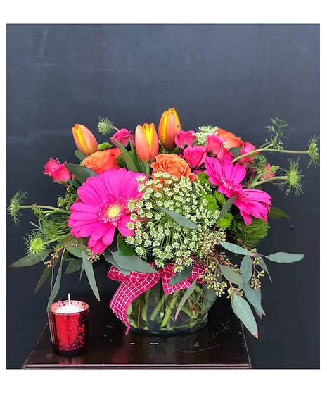 Bright pink and orange flowers in a cylinder vase with bright pink ribbon