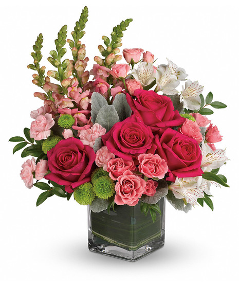 Roses, alstroemeria and snapdragons in a leaf-lined glass vase