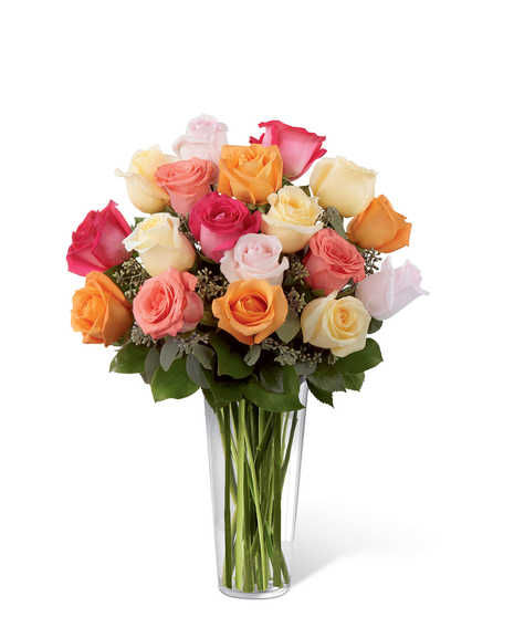 Cream, orange, hot pink, coral and light pink roses with greenery in a clear glass vase