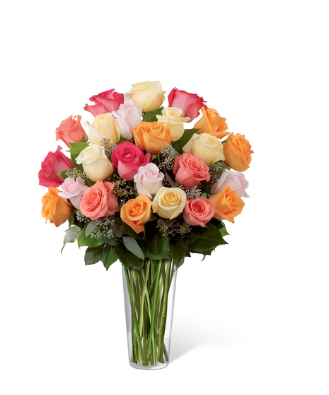 Cream, orange, hot pink, coral and light pink roses with greenery in a clear glass vase