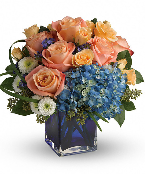 Hydrangea and roses in a blue glass cube vase