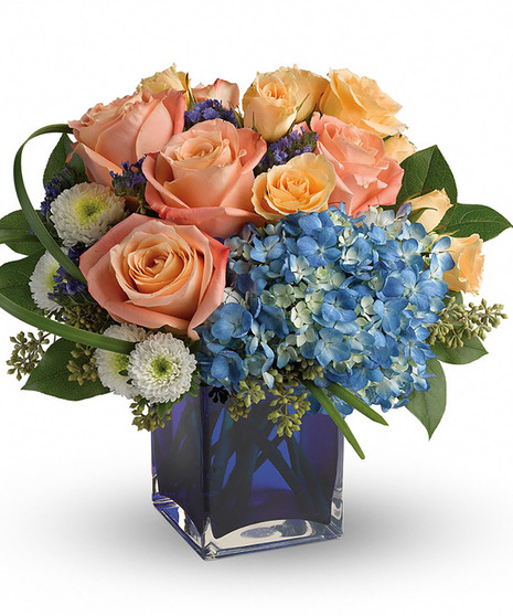 Hydrangea and roses in a blue glass cube vase
