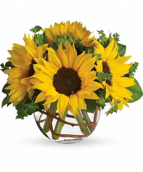 Bowl of yellow sunflowers and greenery in a clear glass vase