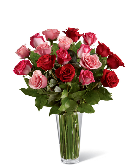 Red, pink and fuchsia roses with greenery in a clear glass vase